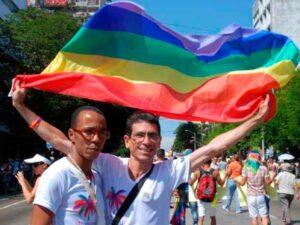 Paquito, levantando bandera del arcoíris, participando en la Conga contra la homofobia en las calles de La Habana